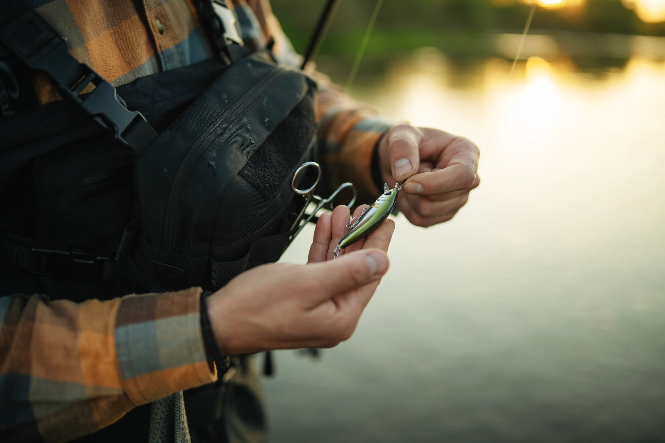 Close-up of a fisherman preparing a lure at sunset