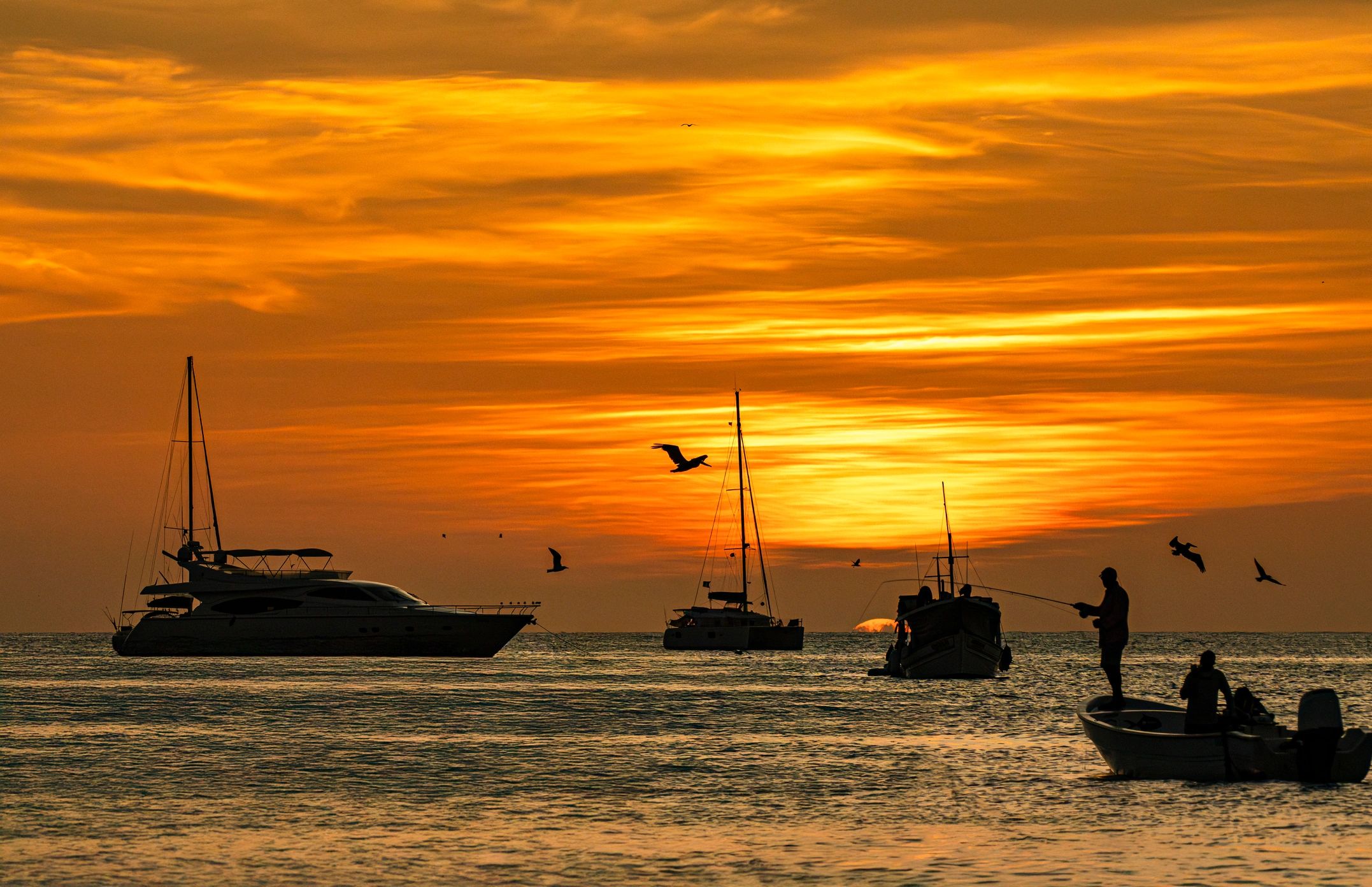 Fishermen on boats at sunset on calm water